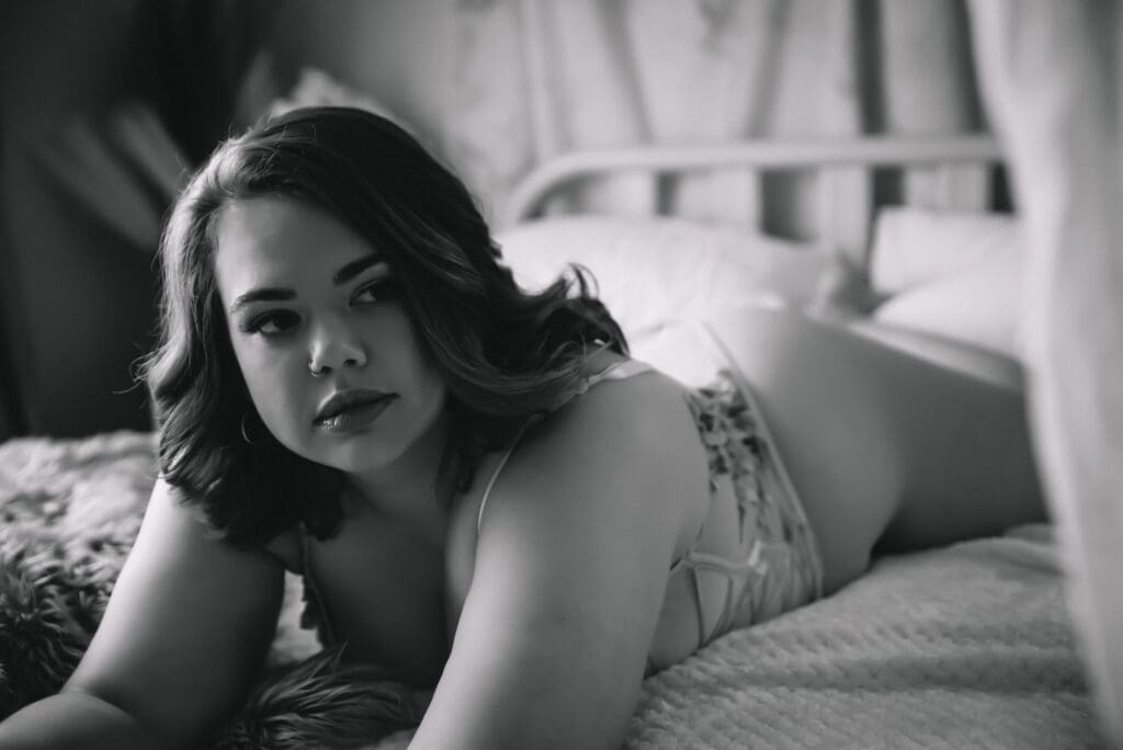 bare elegance guest poses on a canopy bed