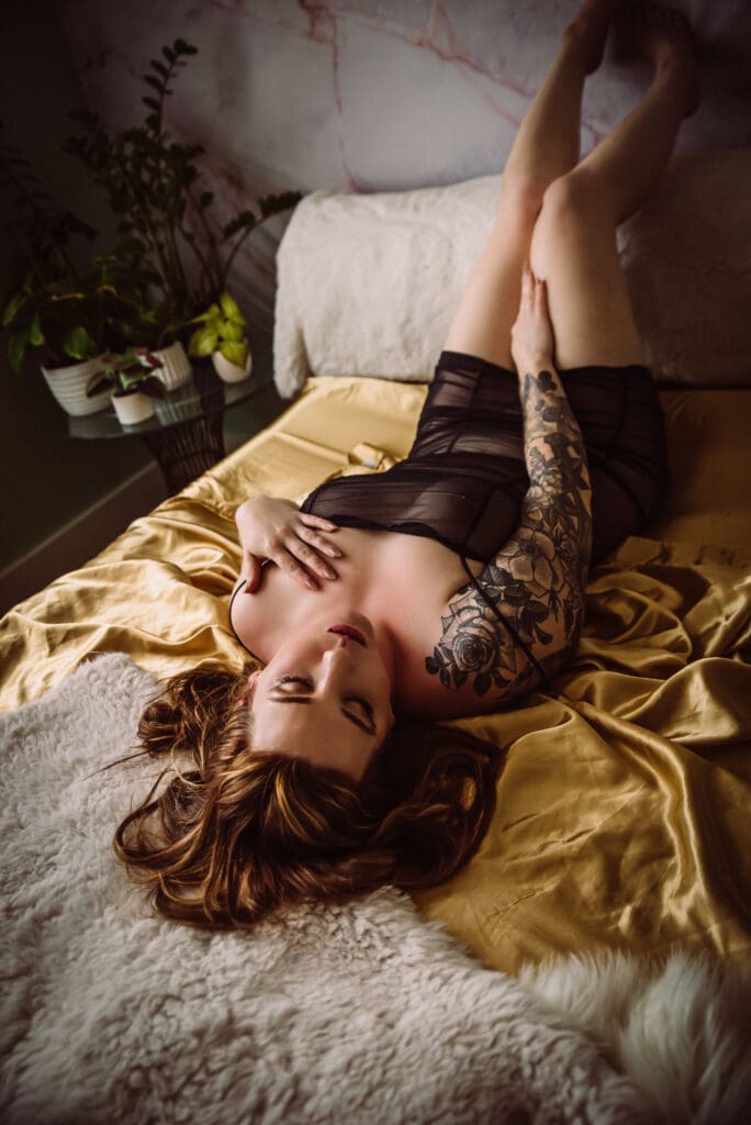 a boudoir photoshoot on a bed with gold satin sheets
