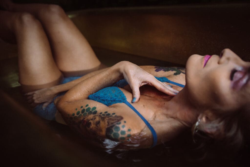 a woman poses in a golden tub showing her manicure