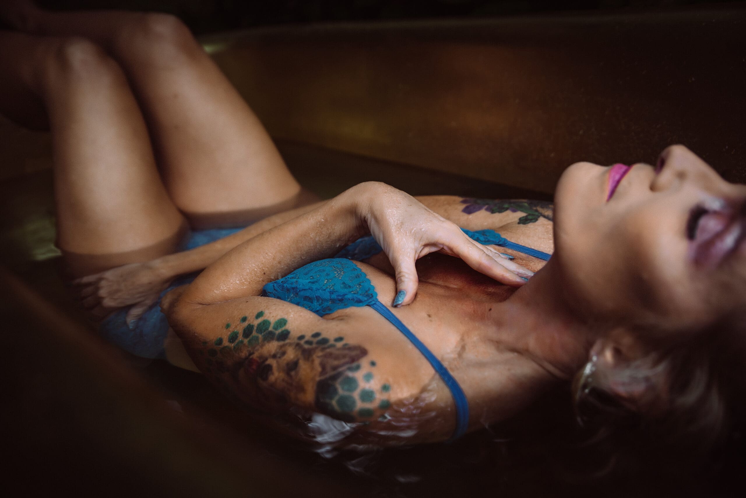 a woman poses in a golden tub showing her manicure