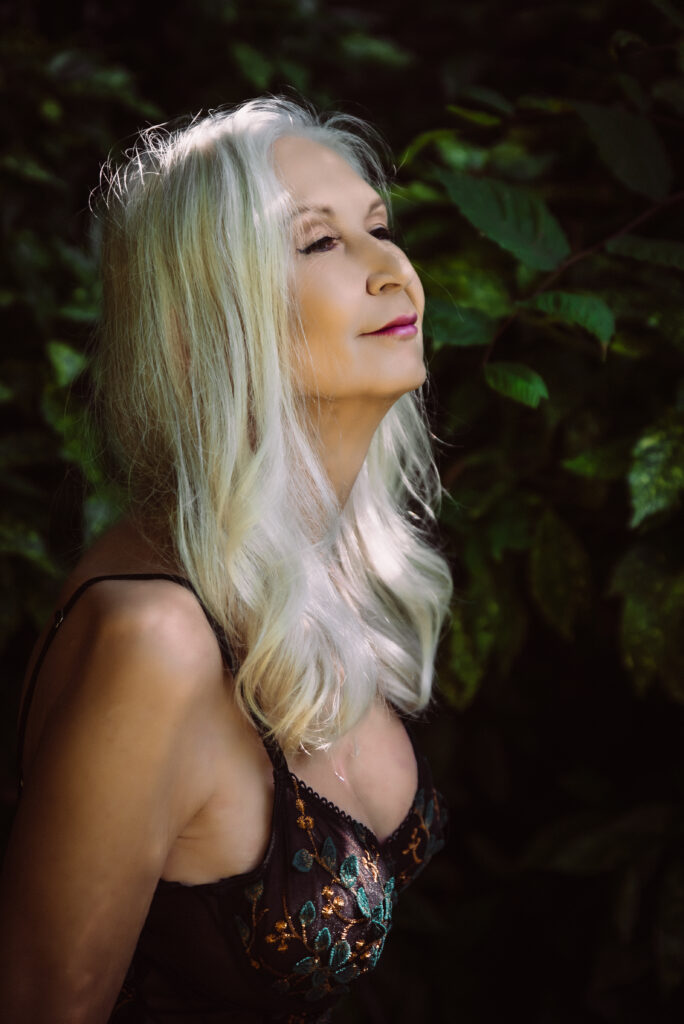 a woman looks peacefully to the left of the frame in an outdoor boudoir photo