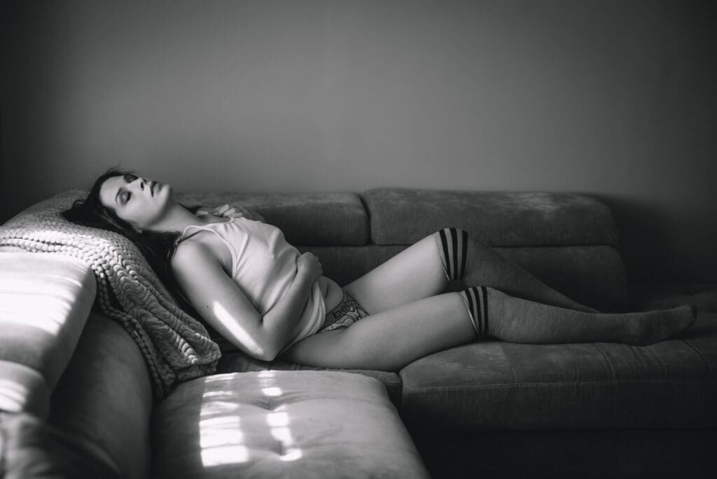 a black and white photo of a boudoir image on a couch