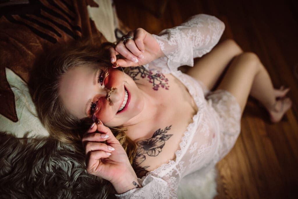 A woman wearing heart shaped glasses with a classic french manicure