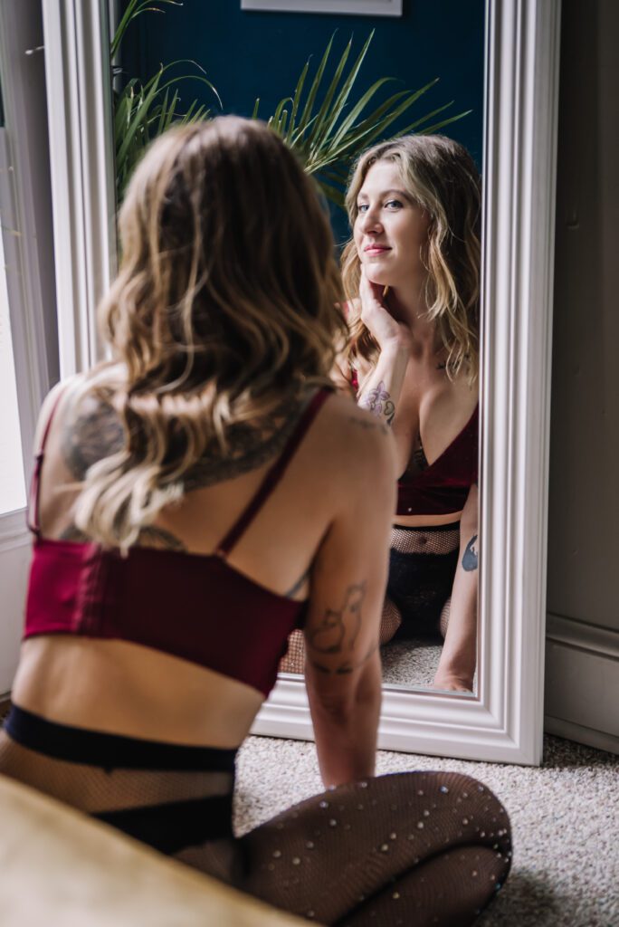 a woman touching her face looking into a mirror with a soft expression near columbia