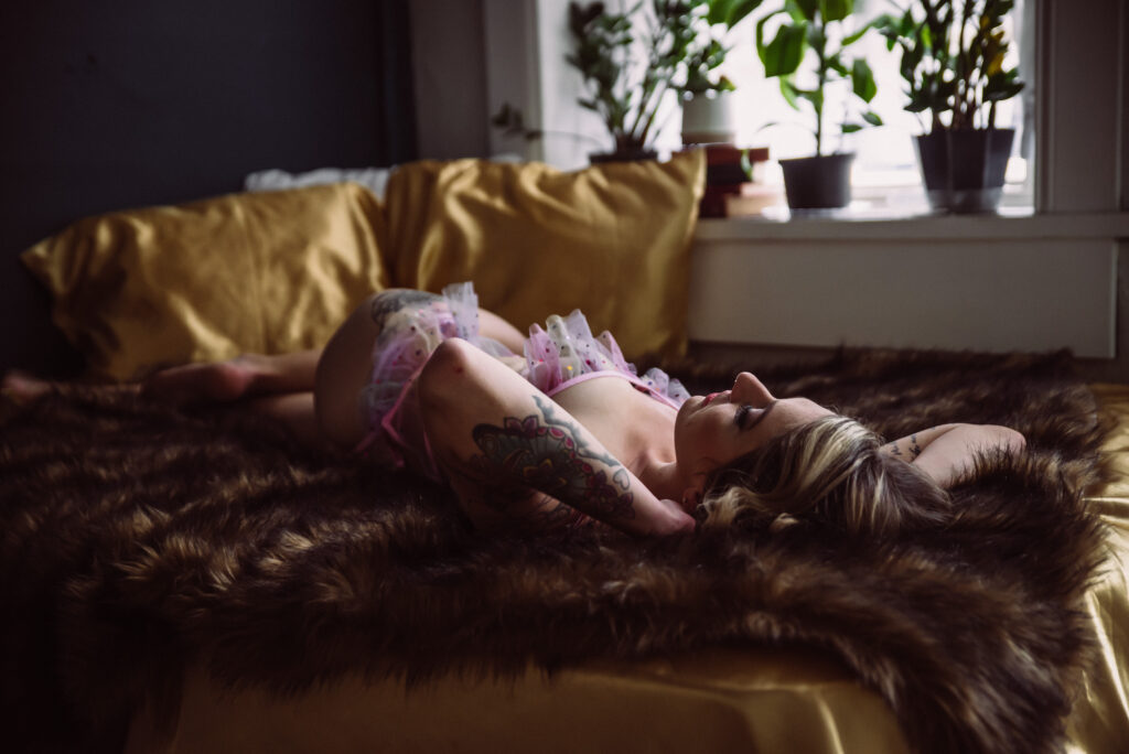 a woman relaxes in a seductive pose on gold satin sheets