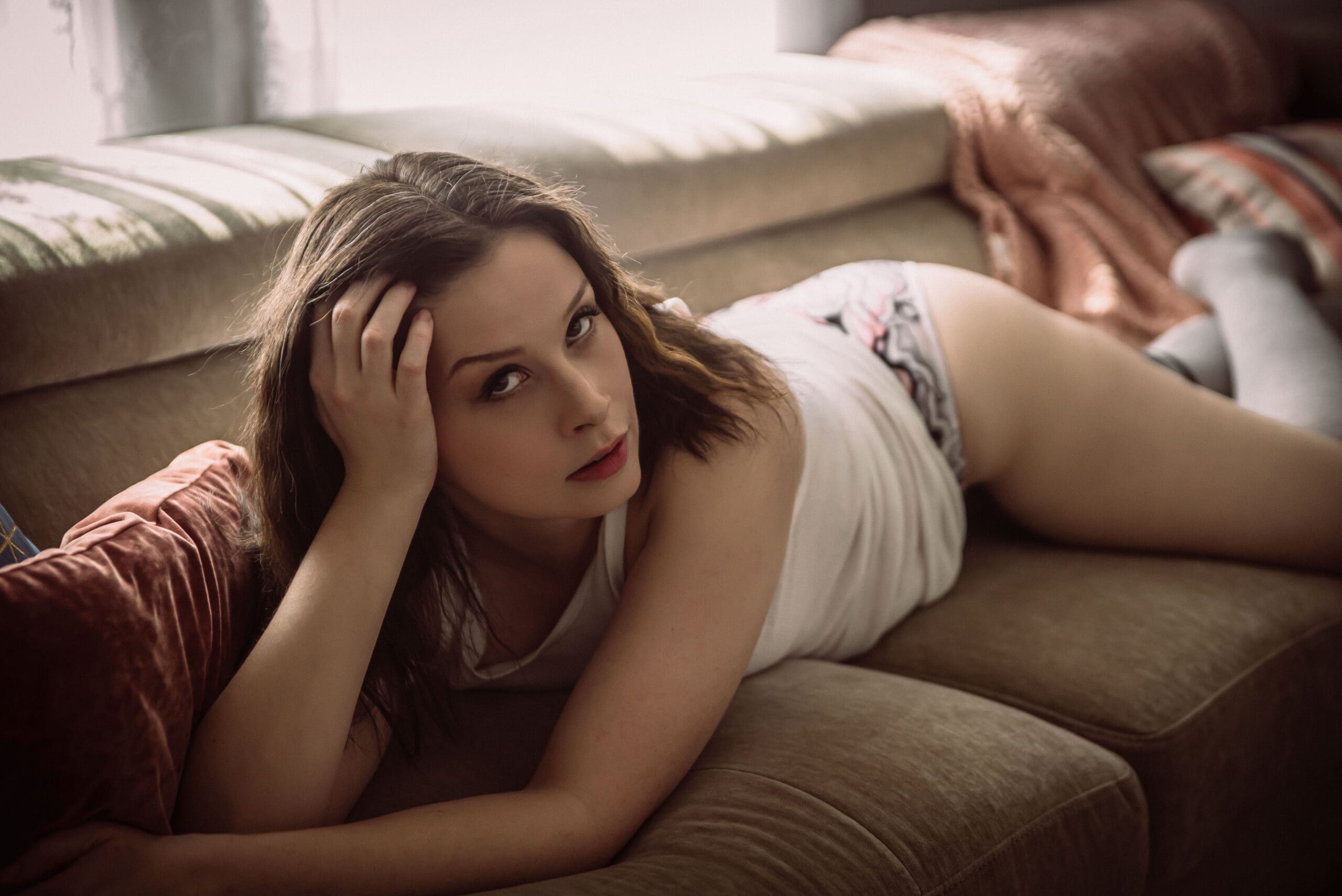 a woman posing confidently on a couch in a south carolina boudoir studio