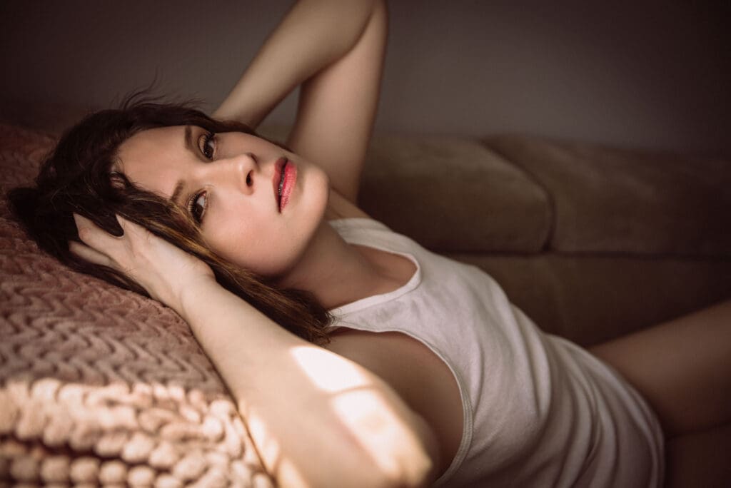 a woman poses with a soft expression in a scene with muted tones