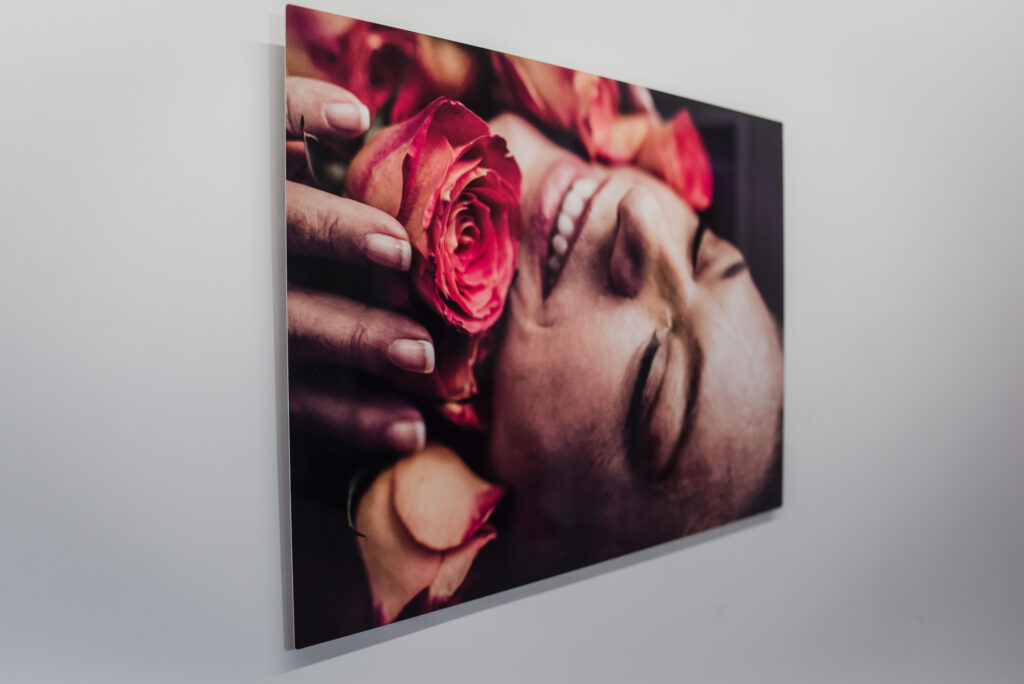 an aluminum wall art piece featuring a photo of a woman holding roses