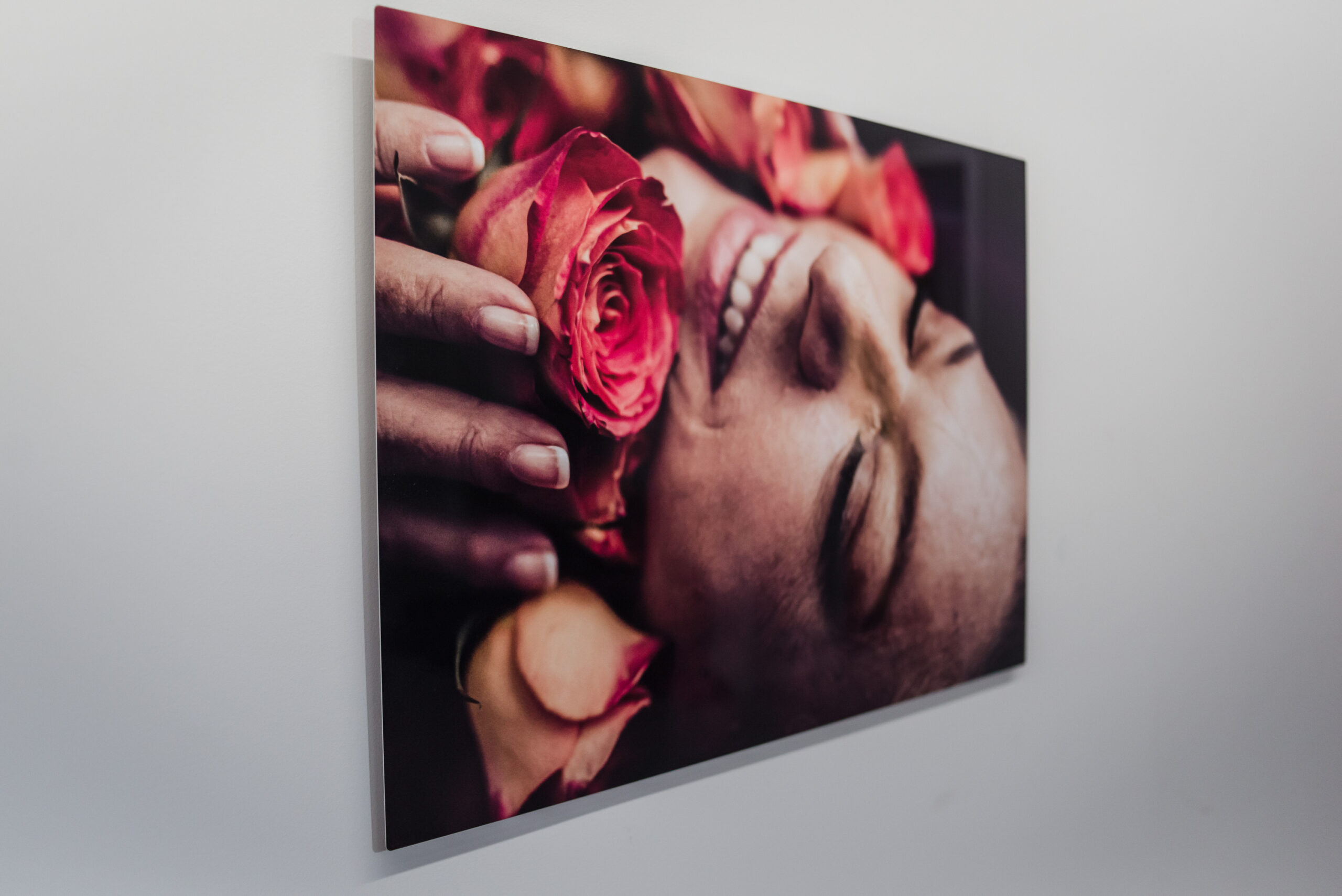 an aluminum wall art piece featuring a photo of a woman holding roses